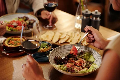 people eating salad and drinking wine